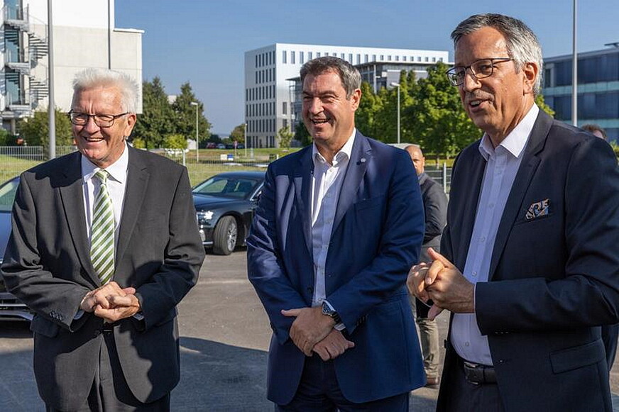 Die beiden Ministerpräsidenten Winfried Kretschmann (Baden-Württemberg) und Markus Söder (Bayern) stehen neben Professor Markus Hölze, dem Vorstand des ZSW in Ulm.