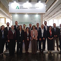 Eine Gruppe Personen posiert vor dem Messestand der Junta de Andalusia.