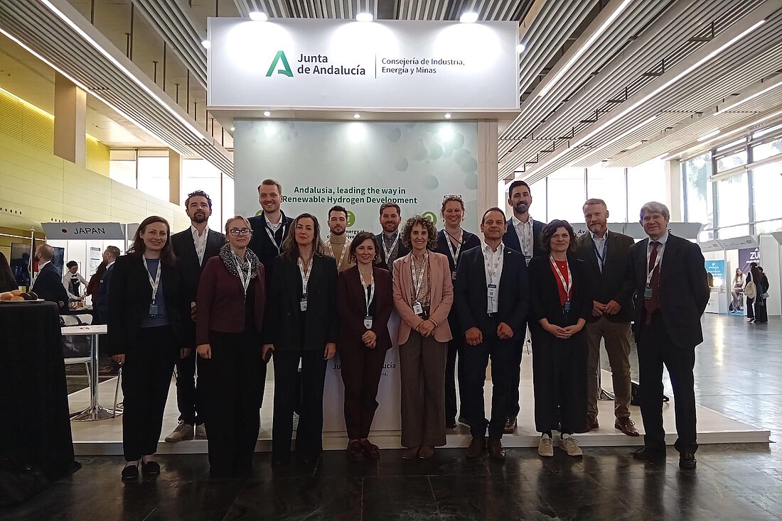 Eine Gruppe Personen posiert vor dem Messestand der Junta de Andalusia.