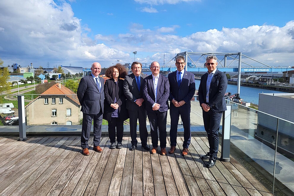 Sechs Personen in Anzug stehen für ein Gruppenfoto zusammen.