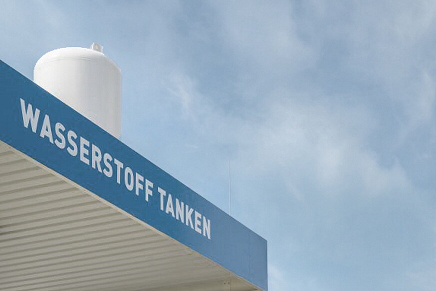 Schriftzug "Wasserstoff tanken" auf blauem Hintergrund einer Wasserstofftankstelle