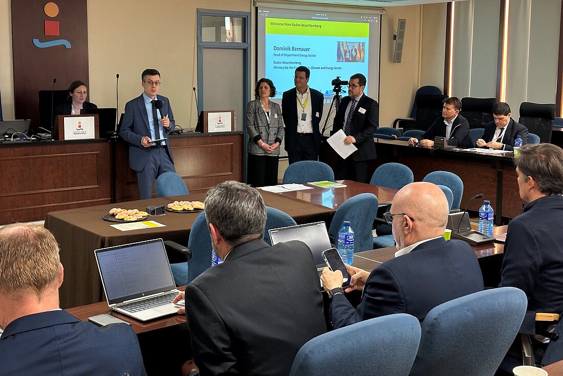 Menschen sitzen in einem Konferenzraum zusammen.