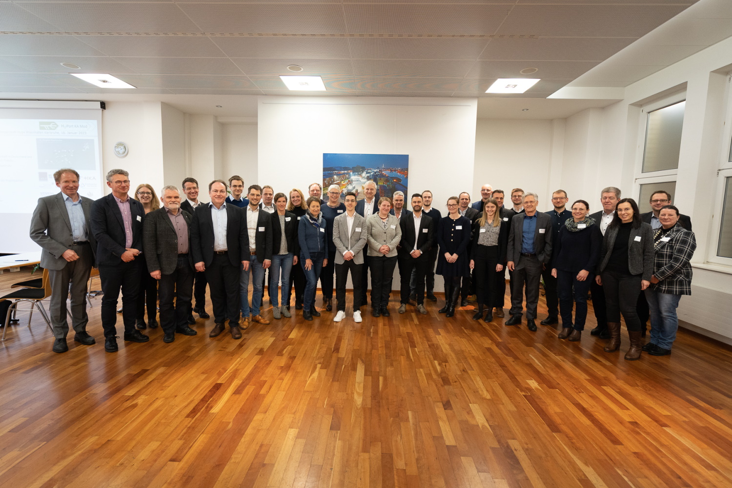 Gruppenfoto von etwa 25 Personen die in einem Halbkreis stehen.