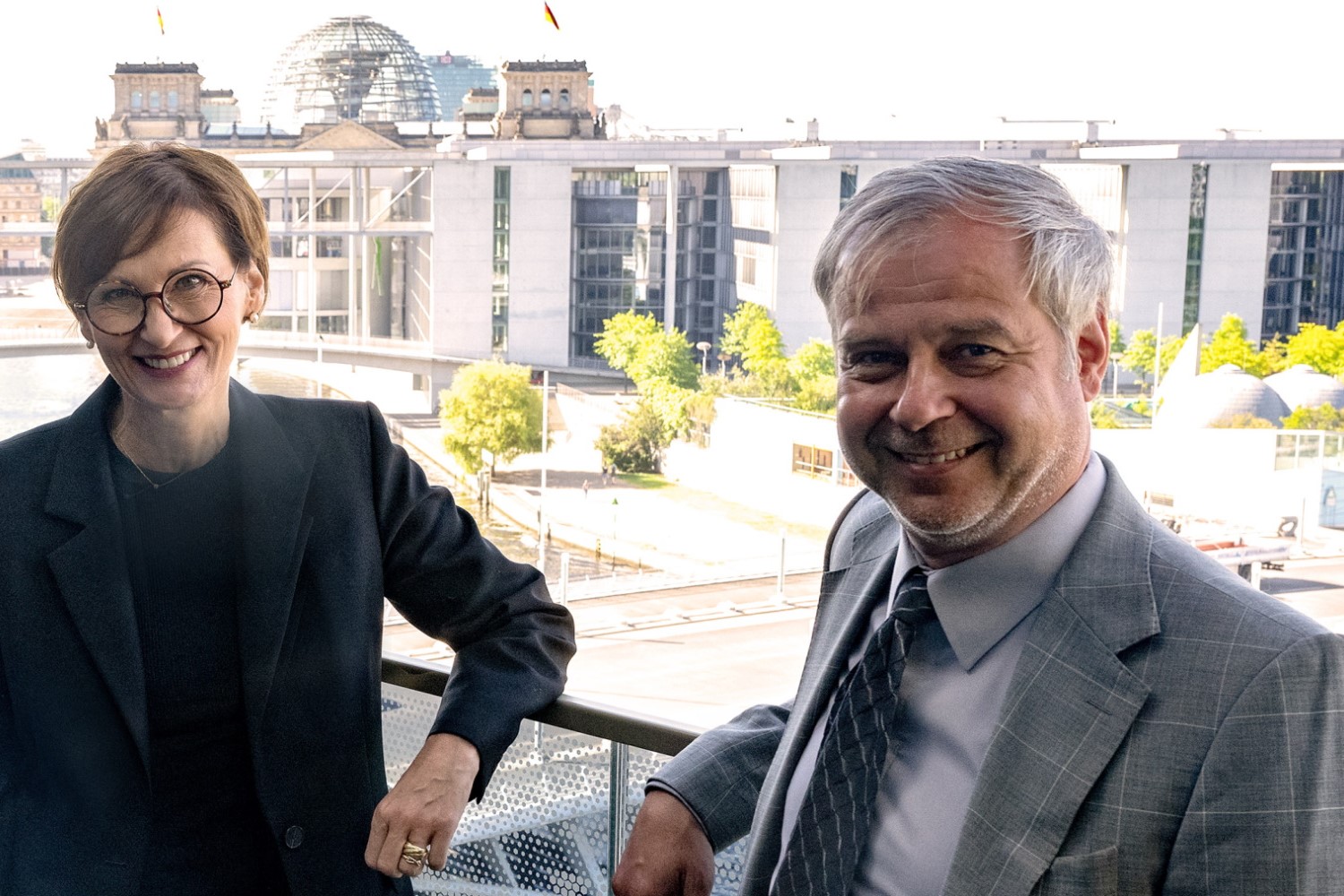 Bundeministerin Bettina Stark-Watzinger posiert gemeinsam mit dem neuen Innovationsbeauftragten Till Mansmann in Berlin mit Blick auf das Reichstagsgebäude.